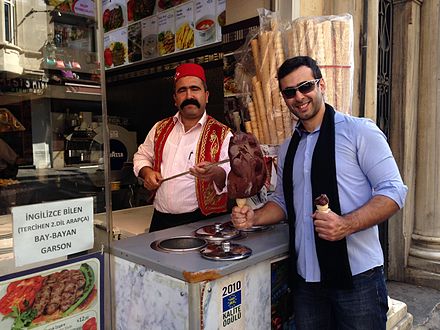 A man purchasing dondurma from a street vendor in Turkey