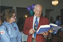 Photographie en couleur d'Aldrin signant un livre.