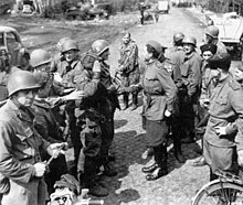 grup de soldats soviètics i americans, incloent dos d'ells Mans'entre-eux se serrent la main