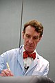 Bill Nye, pada persembahannya, memakai kot makmal berwarna biru cerah dan tali leher kekupu.