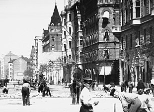 På Birger Jarlsgatan läggs gatsten, 1898. I bakgrunden till höger syns huset (med torn) på fastigheten Sperlingens Backe 47.