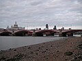 Blackfriars Bridge and the City of London skyline from the South Bank at low tide.jpg