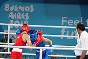 Deutsch: Boxen bei den Olympischen Jugendspielen 2018 Tag 12, 18. Oktober 2018 - Kampf um Bronze im Leichten Weltergewicht Jungen – Hassan Azim (Großbritannien, rot) schlägt Mohammed Boulaouja (Marokko, blau) RSC; Ringrichter ist Wulfren Olivares Peréz (Kolumbien). English: Boxing at the 2018 Summer Youth Olympics on 18 October 2018 – Bronze Medail Match Light Welterweight Boys - Hassan Azim (Great Britain, red) beats Mohammed Boulaouja (Morocco, blue) RSC; Referee is Wulfren Olivares Peréz (Columbia). Español: Boxeo en los Juegos Olímpicos Juveniles de Verano de 2018 en 18 de octubre de 2018 - Medalla de bronce de los hombres ligeros de peso welter: Hassan Azim (Gran Bretaña, rojo) vence a Mohammed Boulaouja (Marruecos, azul) RSC; El árbitro es Wulfren Olivares Peréz (Colombia).