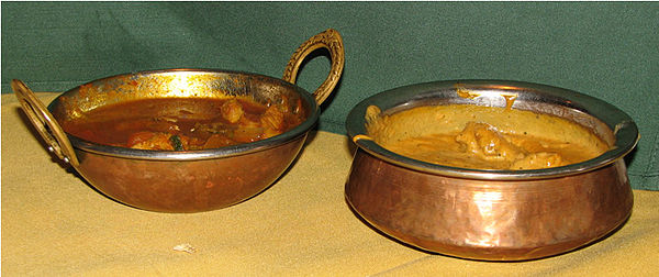 A small, decorative, copper-plated karahi (left) and handi (right) used to serve Indian food