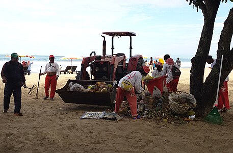 Ngangkut sampah ring pasih Kuta