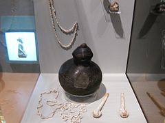 Pipes, necklaces, and a pottery vessel with a lid the shape of a human head, found at Ocmulgee