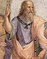 افلاطون با دست چپ "نیمائوس" کتاب مشهور خود را گرفته، دست راست خود را بالا برده و با انگشت به آسمان اشاره می‌کند.