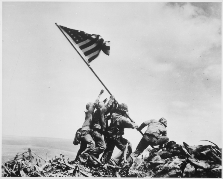 A group of American soldiers raising an American flag on the island Iwo Jima. 