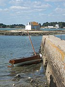 Saint-Cado, dans la Ria d'Étel, à marais basse. Vue sur l'îlot de Nichtarguér avec, au premier plan, un petit voilier amarré à la jetée du port de Saint-Cado.