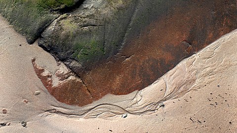 Sand formed by water below a cliff in Govik