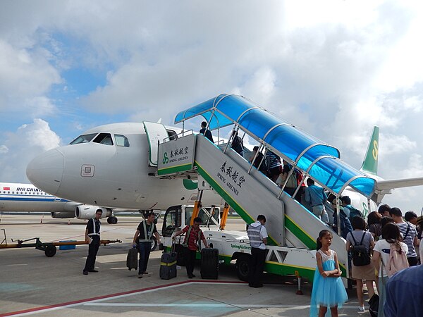 Passengers boarding a Spring Airlines aircraft via passenger boarding stairs at Shanghai Pudong International Airport