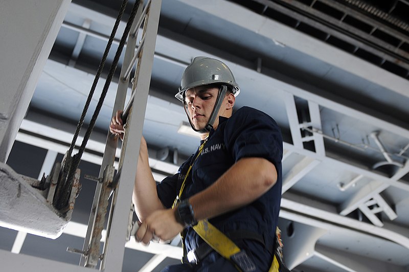 File:US Navy 120118-N-RG587-268 Seaman Apprentice Jordan Cocchiarella descends the ladder of a sliding padeye after performing maintenance in the hangar.jpg