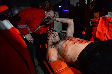 Ukrainian Red Cross Society volunteers administering first aid to a wounded protester, 19 January 2014