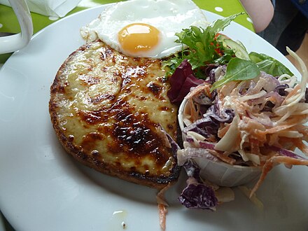Welsh rarebit with an egg, served with coleslaw and a green salad