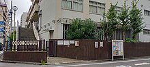 東京都立一橋高等学校の通信制課程生徒用昇降口の反対側から撮影。開庁後であるため昇降口の門は開放している。なお学校教員からは、開放は午前8時と聞いたが、実際は8時よりも少し前に行われた。