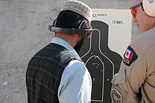 Constable Lorant Haged, Royal Canadian Mounted Police and instructor at the leadership and management course, looks at a target after the Afghan National Police (ANP) ceased fire at a 9mm familirization range 3 Dec.. The ANP are attending a six-month Leadership and Management course where they will also take a criminal Investigation course, leadership and management classes and Rule of Law. The intent of the school is teach the ANP officers and leaders at an advanced level of training that will help them become more effective in running police sub-stations. ANP officers and leaders move toward self-sufficiency DVIDS347314.jpg