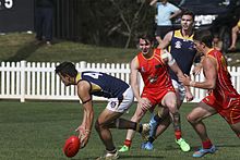 Player performing a pick-up on the run Australian rules pick up.jpg