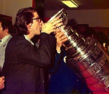Players and team personnel often drink from the Cup to celebrate, as shown here in 1974. BCC 1974 Stanley Cup.jpg