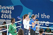 Deutsch: Boxen bei den Olympischen Jugendspielen 2018 Tag 12, 18. Oktober 2018 - Medaillenzeremonie im Fliegengewicht der Mädchen - Gold: Martina La Piana (Italien), Silber: Adijat Gbadamosi (Nigeria), Bronze: Heaven Destiny Garcia (USA); Medaillenübergabe durch Habu Gumel (IOC, Nigeria), Geschenkübergabe durch Dr. Joseph O. Ayeni (Nigeria, AIBA). English: Boxing at the 2018 Summer Youth Olympics on 18 October 2018 – Girl's flyweight Medal Ceremony - Gold: Martina La Piana (Italy), Silver: Adijat Gbadamosi (Nigeria), Bronze: Heaven Destiny Garcia (USA); Medal handover by Habu Gumel (IOC, Nigeria), Gift presented by Dr. Joseph O. Ayeni (Nigeria, AIBA). Español: Boxeo en los Juegos Olímpicos Juveniles de Verano de 2018 en 18 de octubre de 2018 - Ceremonia de la Medalla de peso mosca para niñas - Oro: Martina La Piana (Italia), Plata: Adijat Gbadamosi (Nigeria), Bronce: Heaven Destiny Garcia (Estados Unidos); Entrega de medallas por Habu Gumel (COI, Nigeria), Regalo presentado por Joseph O. Ayeni (Nigeria, AIBA).