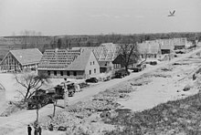 Photographie en noir et blanc du chantier d'un lotissement de larges maisons.