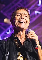 Cliff Richard, who reached the number one slot at Christmas three times (four times with the inclusion of Band Aid II) Cliff Richard - Old Royal Naval Yard Greenwich - Saturday 1st July 2017 CliffGreenwich010717-43 (35672276090) (cropped).jpg