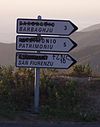 Typical vandalised road signs. The French name of each town has been removed by Corsican nationalists. FLNC is the name of a Corsican nationalist group