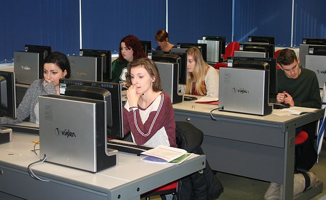 People sat writing at computers