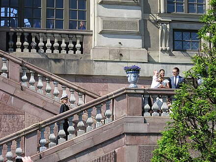 On a rarely used staircase from before 1754, the Crown Princess of Sweden ascends from the Stockholm Palace garden with her husband and baby in 2013.