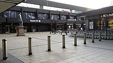 The forecourt and frontage of Euston in 2017, with the statue of Robert Stephenson Euston station entrance, geograph 5441695 by Peter Mackenzie.jpg