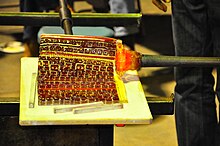 Picking up a murrina sheet onto a blowpipe while blowing glass. Example of picking up murrine onto a blowpipe while blowing glass.JPG