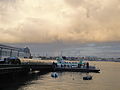 The Gosport Ferry terminal, at Portsmouth Harbour, Portsmouth, Hampshire, seen just after sunrise, with the morning sun still reflected in the clouds.