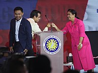 Filipino politicians Isko Moreno and Leni Robredo bump fists before participating in one of the 2022 Philippine presidential debates.