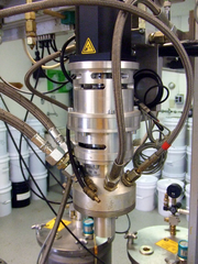 A low-pressure mix head with calibration chamber installed, showing material supply and air actuator lines