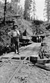 Man standing on rail tracks leading to tunnel, unidentified Bloedel-Donovan lumber operation, ca 1924 (INDOCC 1163).jpg