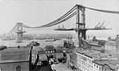 Az épülő Manhattan híd 1909. március 23-án, előtérben az East River kikötőjével (Amerikai Egyesült Államok, New York City)