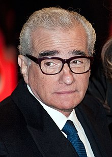 Portrait of Martin Scorsese wearing a suit and a pair of glasses
