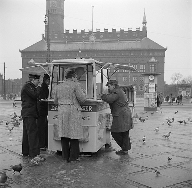 File:Mensen staan te eten bij een kiosk met op de achtergrond het raadhuis, Bestanddeelnr 252-8832.jpg