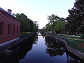 Merrimack Canal viewed from the bridge at Middlesex Street in Lowell, Massachusetts. Moody Street Feeder Gatehouse is visible at left; Lucy Larcom Park at right.