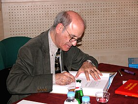 Quino (cartoonist) autographs a book in Paris, 2004.jpg