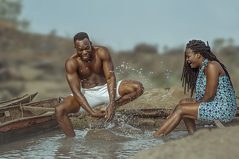 Two lovers playing with water splash by the River Benue.