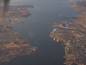 Sydney Harbour in 2008, aerial view showing where HMSC Protector would have been located. On the right side, the red vessel is docked to the government wharves that were used in WWII as HMSC Protector I. On the left-side, the Point Edward Sydport piers, where HMSC Projector II was located, are visible about mid-way in the upper third of the picture. Sydney Harbour aerial view.jpg