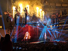Swift performing in a stadium in front of thousands of concertgoers.