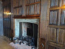 Dark brown wood panelling with a rippled surface, mounted in rectangular panels from floor to ceiling