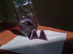 Un cuberdon coupé en deux, montrant le cœur tendre violet foncé et la croûte extérieure rouge rosé