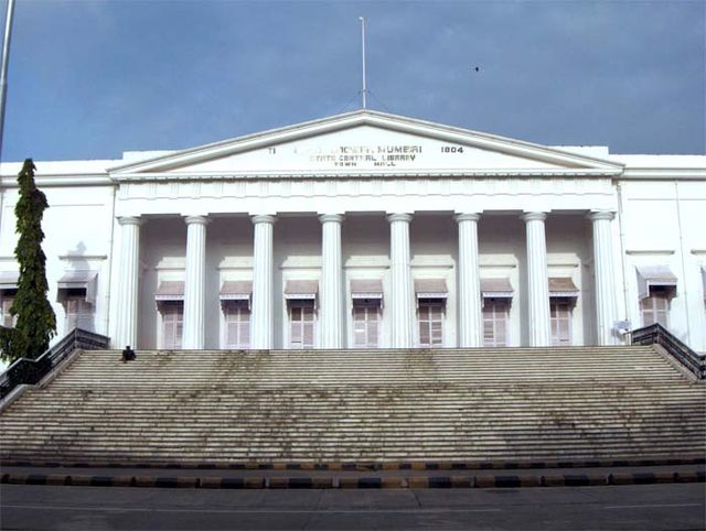 A white building with a triangular façade and wide stairs