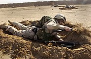 US Navy 030209-N-5319A-006 Construction Electrician 3rd Class Justin Vizcarrondo assigned to Naval Mobile Construction Battalion Seventy-Four (NMCB-74) uses an entrenching tool to dig a hasty scrape