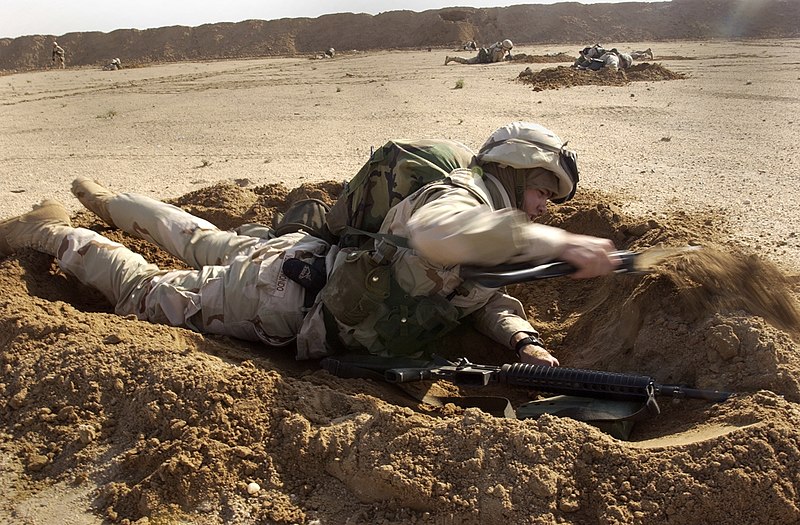 File:US Navy 030209-N-5319A-006 Construction Electrician 3rd Class Justin Vizcarrondo assigned to Naval Mobile Construction Battalion Seventy-Four (NMCB-74) uses an entrenching tool to dig a hasty scrape.jpg