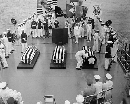 Charette selects a coffin for burial in the World War II Tomb of the Unknown from the two coffins representing World War II (Pacific and European theaters) resting on each side of the Korean unknown [center] during ceremonies on board the USS Canberra, May 26, 1958