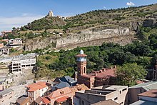 vue du mont Tabori sur une colline bâtie d'un édifice dont on voit trois tours de couleur grise