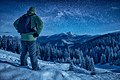 A climber standing on a snowy slope at night.jpg